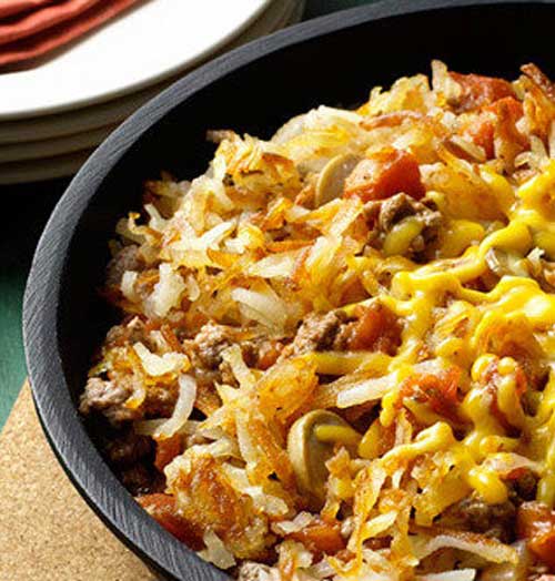 Recipe for Cheesy Hashbrown Skillet Dinner - This 30-minute skillet dinner made with beef, potatoes,cheese, onions and tomatoes is incredibly easy and very satisfying.
