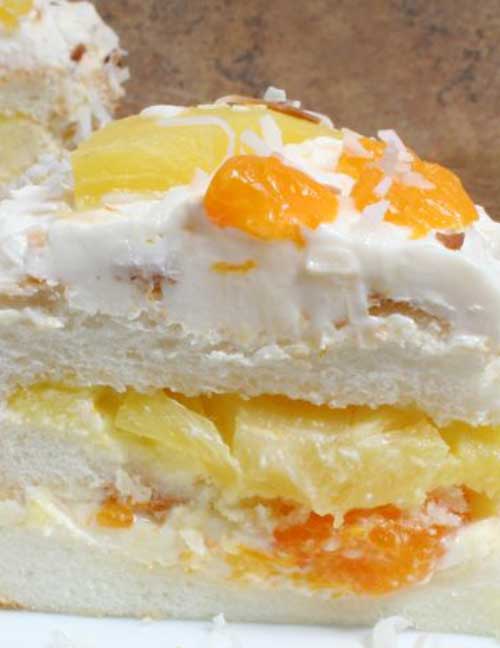 An angel food cake with lots of fresh flavor. The pineapple, mandarin oranges, and toasted coconut give this Ambrosia Cake recipe a tropical flair.