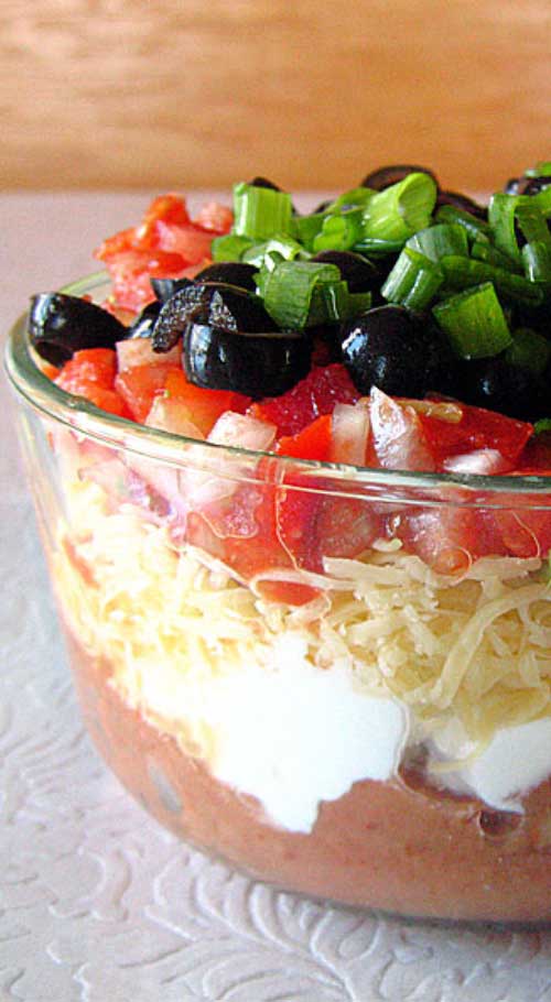 Without a doubt, my favorite party food is this Tex-Mex Seven Layer Dip. With one deft swoop of a wide-brimmed tortilla chip, you can shovel seven unique tastes and textures into your open mouth at once.