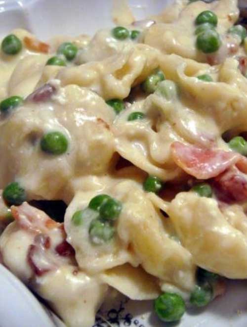 This Simple Creamy Tortellini Alfredo is so creamy and delish! You could easily swap out the peas for broccoli or add chicken instead of bacon.