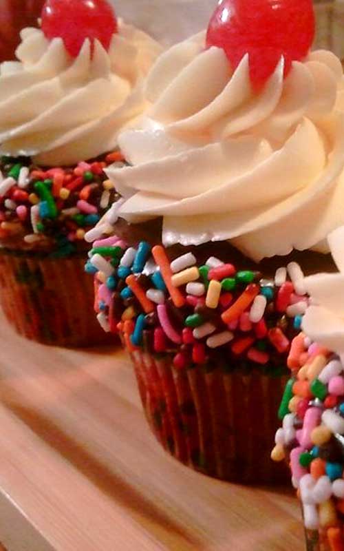 Recipe for Banana Split Cupcakes - Enjoy the delicious flavors of your favorite ice cream dessert in these Banana Split Cupcakes. Topped with a smooth buttercream, rich chocolate ganache, sprinkles, and a cherry on top.